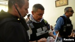 United Nations chemical weapons expert inspects map during visit to site of an alleged attack in Damascus suburbs of Zamalka, Aug. 28, 2013.