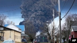 FILE - A black plume rises over East Palestine, Ohio, as a result of a controlled detonation of a portion of the derailed Norfolk Southern trains, Feb. 6, 2023. 