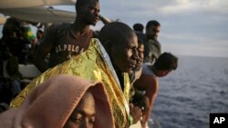 Migrants look out from the deck of the Spanish NGO ProActiva Open Arms vessel as they wait to reach the Italian coast on the Mediterranean Sea a day after being rescued off the Libyan coast, Sept. 7, 2017.
