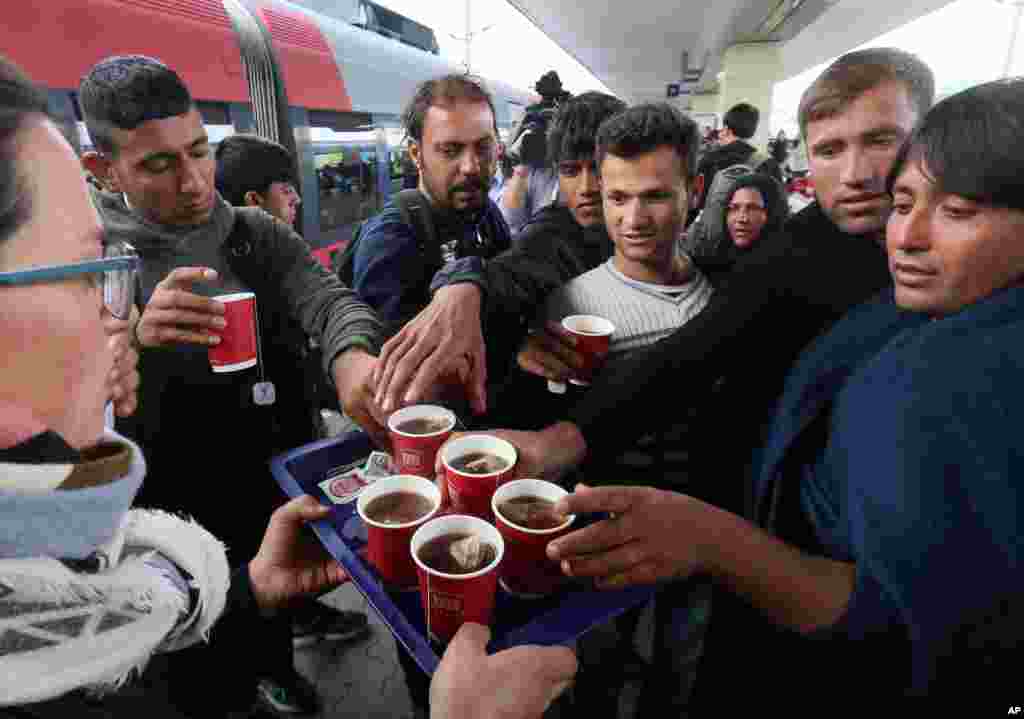 Migrants get some tea as they arrive at the Westbahnhof station in Vienna, Austria, Sept. 6, 2015.