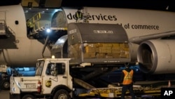 FILE - In this photo provided by Canada's Department of National Defence, shipments of initial doses of COVID-19 vaccines are unloaded, late Sunday, Dec. 13, 2020, in Canada. 