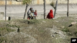 Kashmiri villagers walk past a graveyard containing unidentified dead at Bimyar, about 60 miles (96 kilometers) west of Srinagar, India (File Photo)