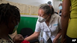 Jean Gough, UNICEF regional director for Latin America and the Caribbean, greets an infant in a malnutrition clinic in Les Cayes, Haiti, May 26, 2021. 