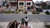 Jorge Enrique recibe ayuda de la cuidadora Silvia García para caminar de regreso a casa después de hacer ejercicio en un parque cercano en La Habana, Cuba, 8 de marzo de 2024. REUTERS/Alexandre Meneghini