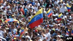 An opposition supporter waves a national flag during a gathering with Venezuelan opposition leader Juan Guaido, in Caracas on Feb. 2, 2019. 