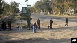 In this image taken during a trip organized by Libyan authorities, Libyan soldiers control a checkpoint near the city of Misrata, April 9, 2011