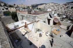 Palestinian Jamil Masalmeh uses a power tool to destroy an apartment he had added to his home years earlier, in the Silwan neighborhood of east Jerusalem, Sept. 9, 2019.