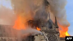 Flames and smoke are seen billowing from the roof at Notre Dame Cathedral in Paris, April 15, 2019.