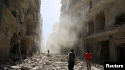 Men inspect the damage after an airstrike on the rebel held al-Qaterji neighbourhood of Aleppo, Syria, Sept. 25, 2016. 
