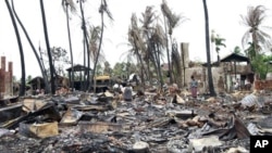 People shift through damaged buildings in Sittwe, capital of Rakhine state, western Burma, June 16, 2012.