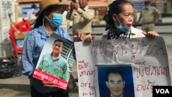 អ្នកស្រី ​សុខ​ បូលីម៉ា​ ​អាយុ​៥០​ឆ្នាំ​ ឈរកាន់​រូបថត​ស្វាមីគាត់​ គឺ​លោក​ ឃឹម ភាណា​ នៅមុខ​សាលាដំបូង​រាជធានី​ភ្នំពេញ​ ថ្ងៃទី​៣​ ខែកក្កដា​ ឆ្នាំ​២០២០​។ (ហ៊ុល រស្មី/វីអូអេ)