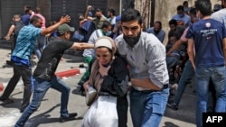 Warga Palestina mengevakuasi warga sipil dari sebuah bangunan di kota Gaza untuk menghindari serangan udara Israel , Selasa (11/5). 