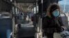 Seorang perempuan mengenakan masker di sebuah bus di tengah wabah virus korona yang melanda negara itu, di Beijing, China, 15 Februari 2020. 