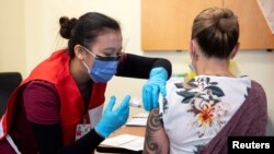 Nurse Venus Lucero administers the first Pfizer-BioNTech COVID-19 vaccine at the Civic Hospital to Jo-Anne Miner at a vaccination clinic in Ottawa, Ontario, Canada, Dec. 15, 2020.