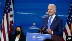 President-elect Joe Biden speaks as Vice President-elect Kamala Harris listens at left, during an event to introduce their nominees and appointees to economic policy posts at The Queen theater, Dec. 1, 2020, in Wilmington, Del.
