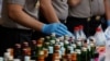 Police prepare evidence during a press conference, April 11, 2018, regarding the arrests of suspects linked to the production and sale of illegal bootleg alcohol, which claimed the lives of more than 80 people this week in Jakarta and nearby West Java province.