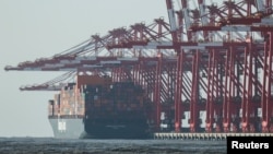 Kранови стојат во близина на товарен брод во пристаниште надвор од Шангај, 7 февруари 2025 година
