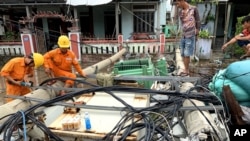 Workers clear toppled electric lines during the landfall of tropical storm Noul, in Hue, Vietnam, Sept. 18, 2020.