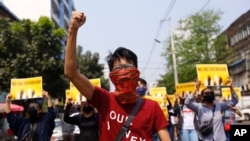 Anti-coup protesters gesture during a march in Yangon, Myanmar, March 26, 2021.