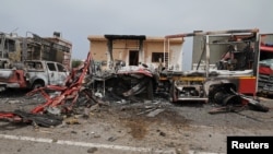 FILE - Damaged vehicles and buildings are seen at Mitiga airport after it was hit by shelling, in Tripoli, Libya, May 10, 2020. 