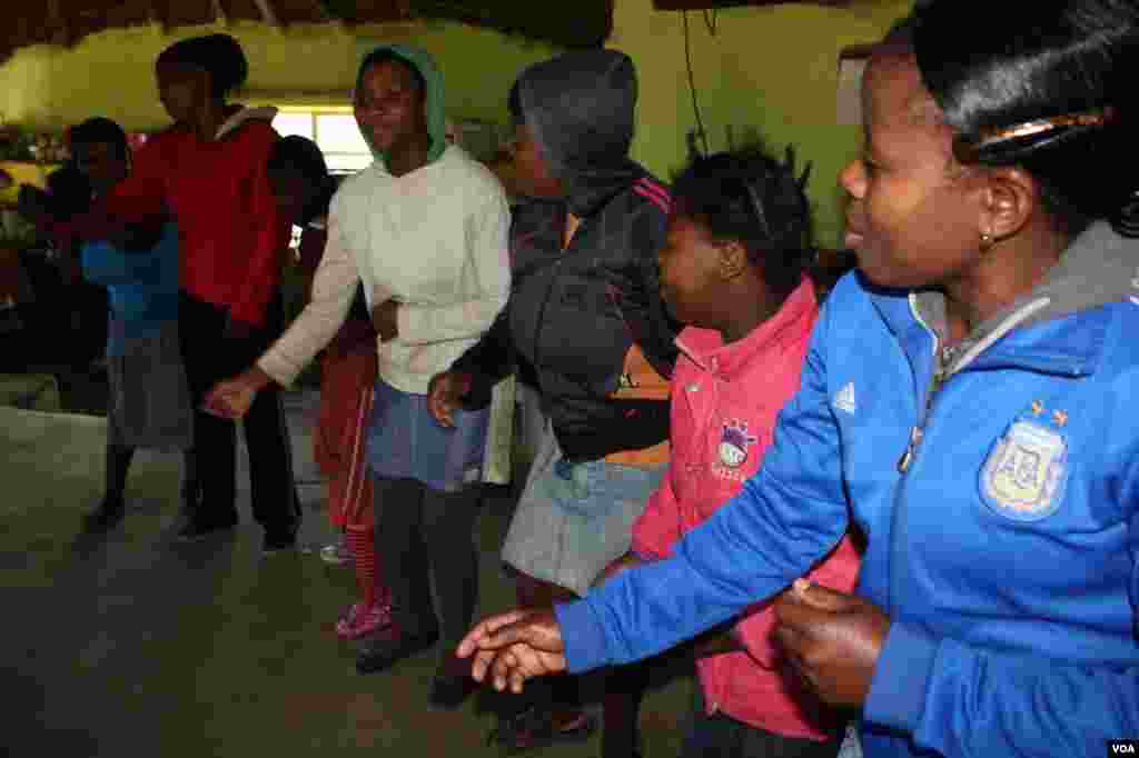 Residents of Ikhaya Loxolo, or &quot;Home of Peace,&quot; sing and dance. (VOA / D. Taylor)