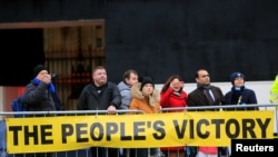 People stand behind a banner supporting the results of the general election, in London, Britain, Dec. 13, 2019.