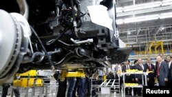 FILE - Vingroup's chairman Pham Nhat Vuong guides Vietnam's Prime Minister Nguyen Xuan Phuc during a tour of a Vinfast auto plant on the occasion of its opening ceremony in Hai Phong city, June 14, 2019.
