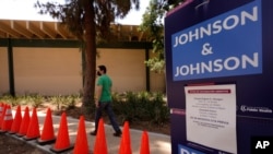 Carlos Arrendondo arrives for his appointment to get vaccinated, as banners advertise the availability of the Johnson & Johnson and Pfizer COVID-19 vaccines at a county-run vaccination site in Los Angeles, July 22, 2021.