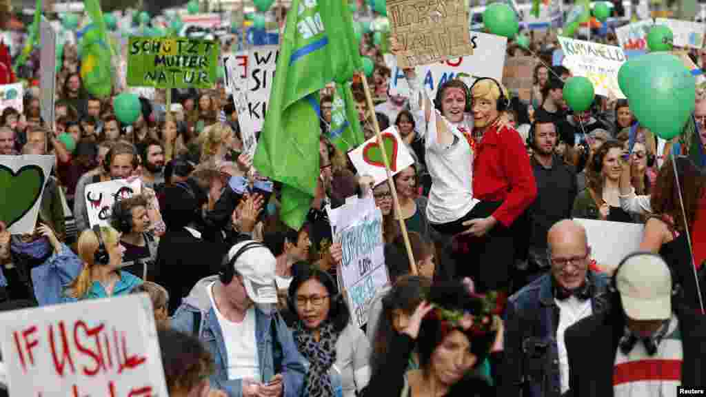 Para demonstran di Berlin (21/9) memegang spanduk dan menari dalam Pawai Perubahan Iklim yang menuntut politisi mengambil tindakan lebih keras untuk melindungi iklim.&nbsp;(Reuters/Thomas Peter) 