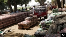 FIle - South Sudanese men inspect crates of soft drinks that were unloaded at the port in Juba, Southern Sudan.
