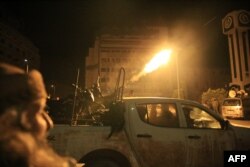 Rebel forces shoot in the air as they parade in their vehicles through the streets of the central Syrian city of Homs early on Dec. 8, 2024, after they entered Syria's third city overnight.