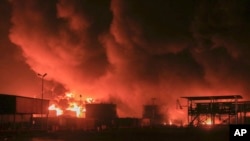 FILE - Oil tanks burn at the port in Hodeidah, Yemen, July 20, 2024. The Israeli army said it has struck several Houthi targets in western Yemen following a fatal drone attack by the rebel group in Tel Aviv the previous day.