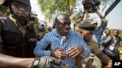 FILE - Uganda's main opposition leader Kizza Besigye, center, is arrested by police and thrown into the back of a blacked-out police van which whisked him away and was later seen at a rural police station, outside his home in Kasangati, Uganda, Feb. 22, 2016. 