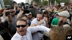 Two supporters of white nationalist Richard Spencer clash with a crowd of protesters after Spencer spoke at the University of Florida in Gainesville, Oct. 19, 2017. 