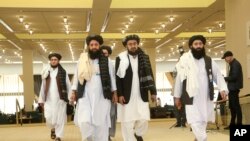 FILE - Members of Afghanistan's Taliban delegation arrive for the signing of an agreement between the Taliban and U.S. officials, in Doha, Qatar, Feb. 29, 2020.