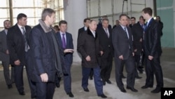 Russian President Vladimir Putin, center, visits the main press center at a coastal Olympic cluster in the Black Sea resort of Sochi, Feb. 7, 2013.