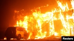 A structure is seen engulfed in flames during the Camp Fire in Paradise, California, Nov. 8, 2018. 