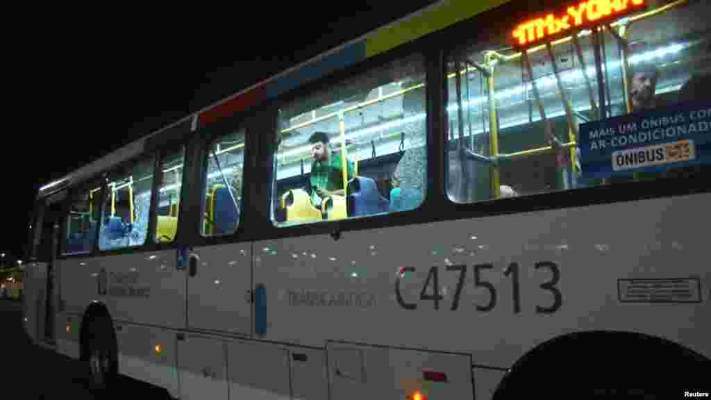 People are shown on an official media bus after its window was shattered while driving journalists to the Main Transport Mall from the Deodoro Stadium of the Rio 2016 Olympic Games in Rio de Janeiro, Aug. 9, 2016. 