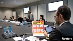 Pascal Strupler of the Federal Office of Public Health holds a flyer prior to a meeting of the task force of the Federal Office of Public Health on the prevention of the further spread of the coronavirus, in Bern, Switzerland, Feb. 28, 2020.