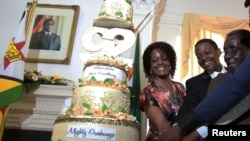 Tổng thống Robert Mugabe cùng vợ và con trai cắt bánh mừng sinh nhật lần thứ 92 của ông ở Harare hôm 22/2.
