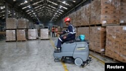 FILE - Employees work at the Kenya Cane spirit production line at the East African Breweries Limited factory in Ruaraka factory in Nairobi, Kenya, April 6, 2018. 
