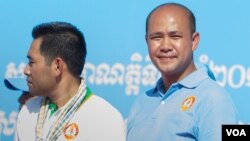 FILE - Hun Many, right, the youngest son of Prime Minister Hun Sen, stands on CPP's campaign stage while his father gives a speech to thousands of supporters, June 2, 2017. (Neou Vannarin/VOA Khmer) 