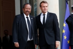 France's President Emmanuel Macron, right, welcomes Sudanese Prime Minister Abdalla Hamdok prior to a meeting at the Elysee palace in Paris, Sept. 30, 2019.