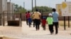 Immigrants seeking asylum leave a cafeteria at the ICE South Texas Family Residential Center, Aug. 23, 2019, in Dilley, Texas.
