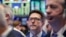 James Matthews, center, works with fellow traders on the floor of the New York Stock Exchange, Oct. 5, 2016.