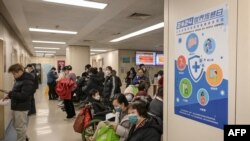 1月8日，戴著口罩的人們在北京一家醫院呼吸科門診區等候。