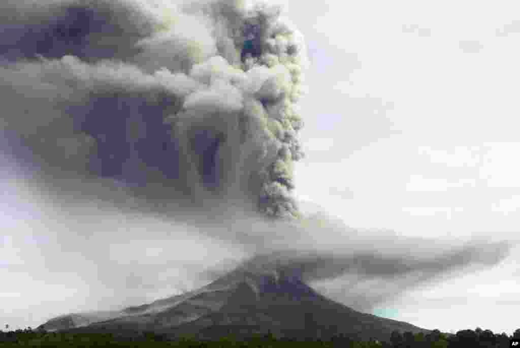 Mount Sinabung spews volcanic material as it erupts as seen from Tiga Pancur, North Sumatra, Indonesia, Nov. 18, 2013. 