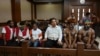 Activists Dano Anes Tabuni, right, Ambrosius Mulait, 2nd right, Paulus Suryana Ginting, Arina Elopere, 3rd left, Charles Kossay, 2nd left, and Isay Wenda, left, wait for their trial in Jakarta, Jan. 20, 2020.