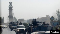 FILE - A military convoy travels along the main road of Kandahar as seen from the glass window of a U.S. military armored vehicle, in Afghanistan, Oct. 5, 2010. 