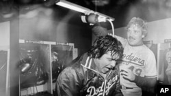 FILE - Los Angeles Dodgers pitcher Fernando Valenzuela is doused with champagne by teammate Tom Niedenfuer after the Dodgers won the National League title over the Expos, in Montreal, Oct. 20, 1981.